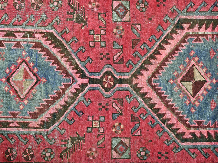 a red rug with a blue, green, and pink design