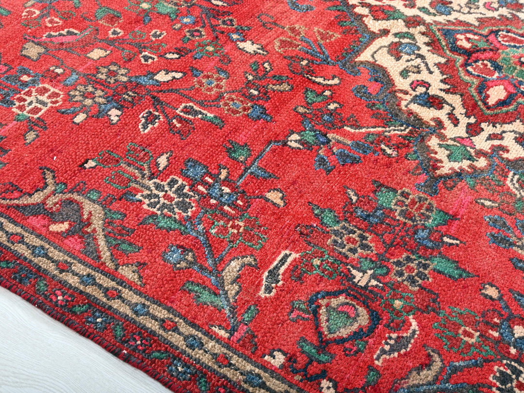 a red rug with a floral design on it