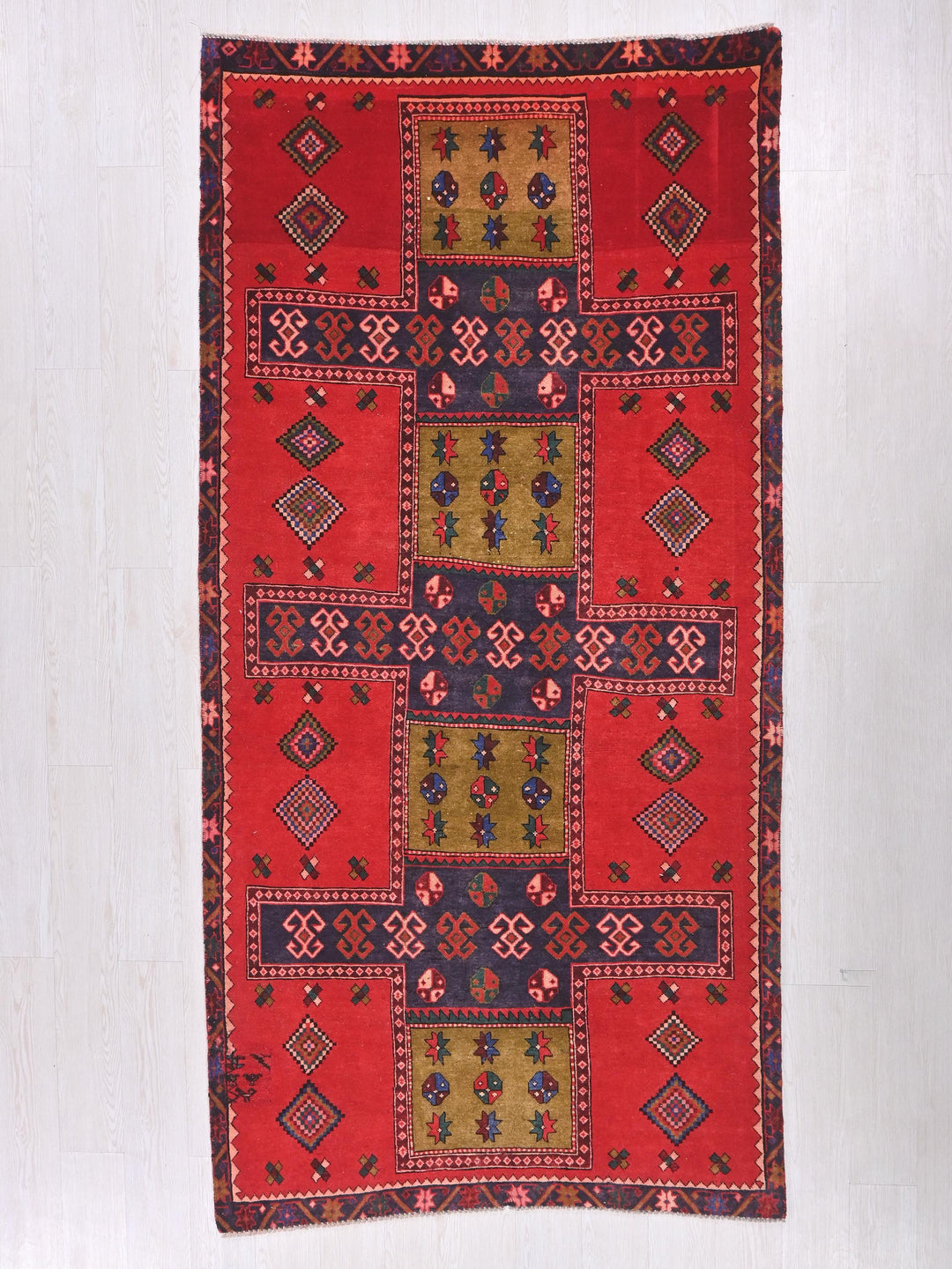a red rug with a design of squares and flowers