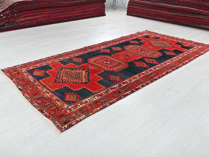 a red and black rug sitting on top of a white floor
