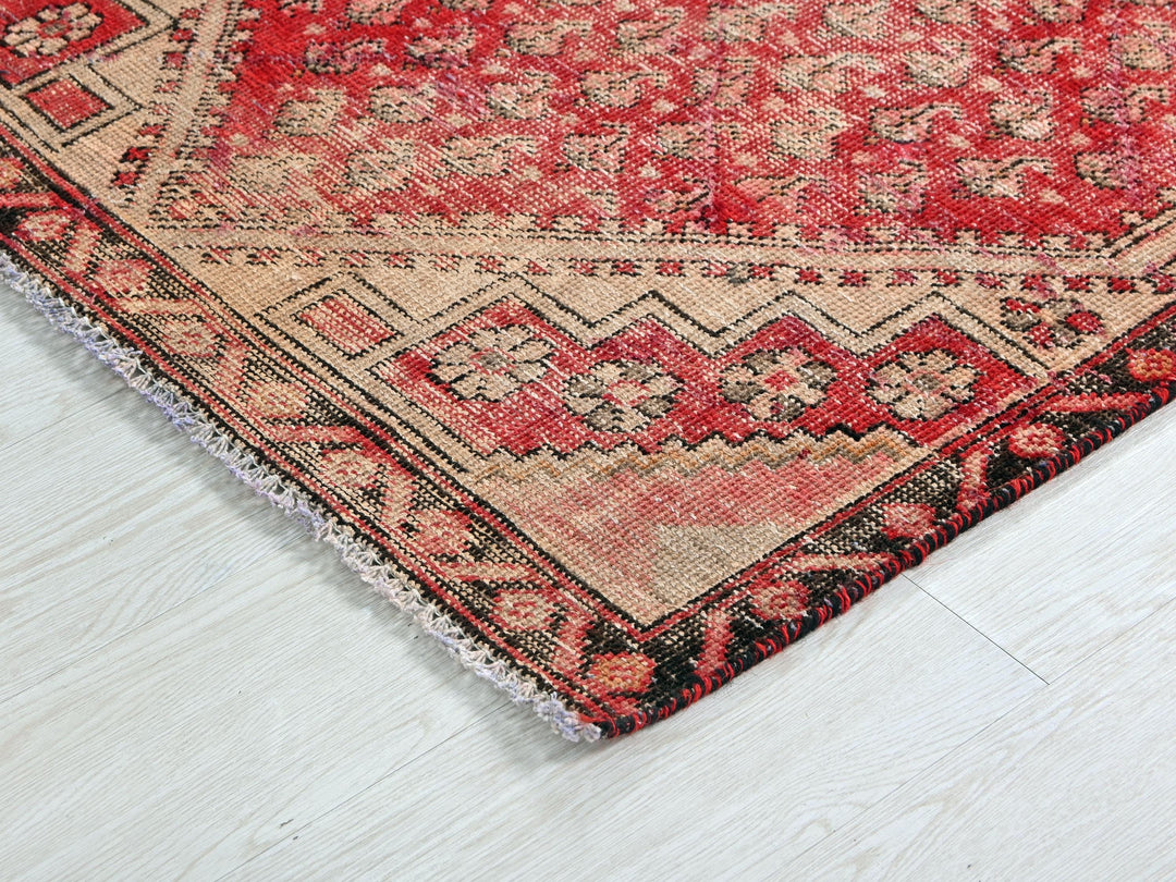 a red and black oriental rug on a white floor