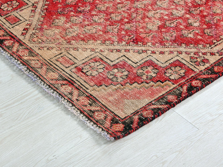 a red and black oriental rug on a white floor
