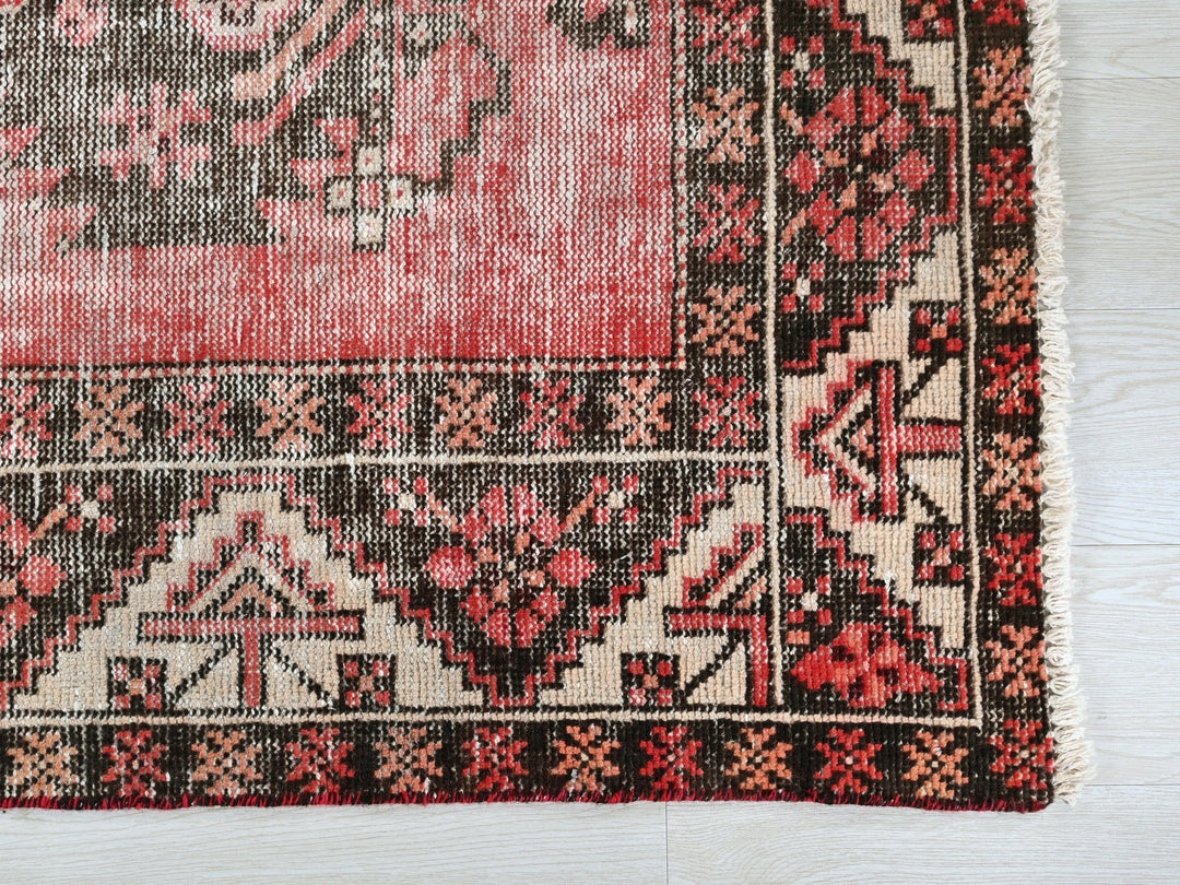a red and black rug on a white floor