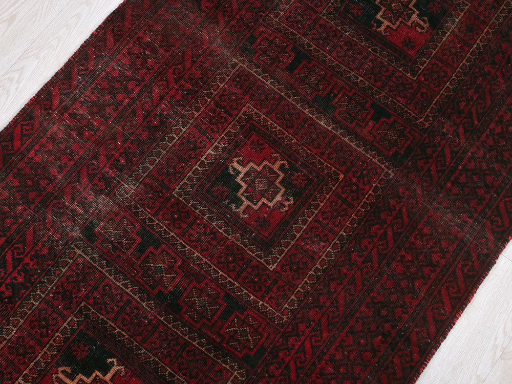 a red rug with a black and red design on it