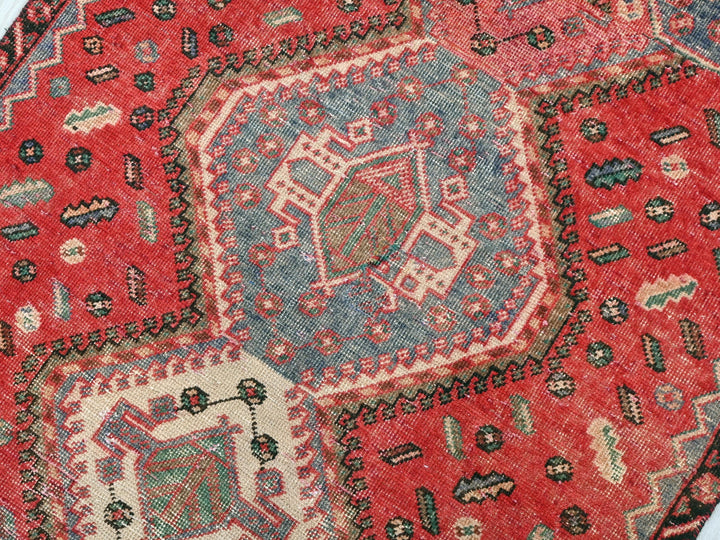 a close up of a red rug on a white surface