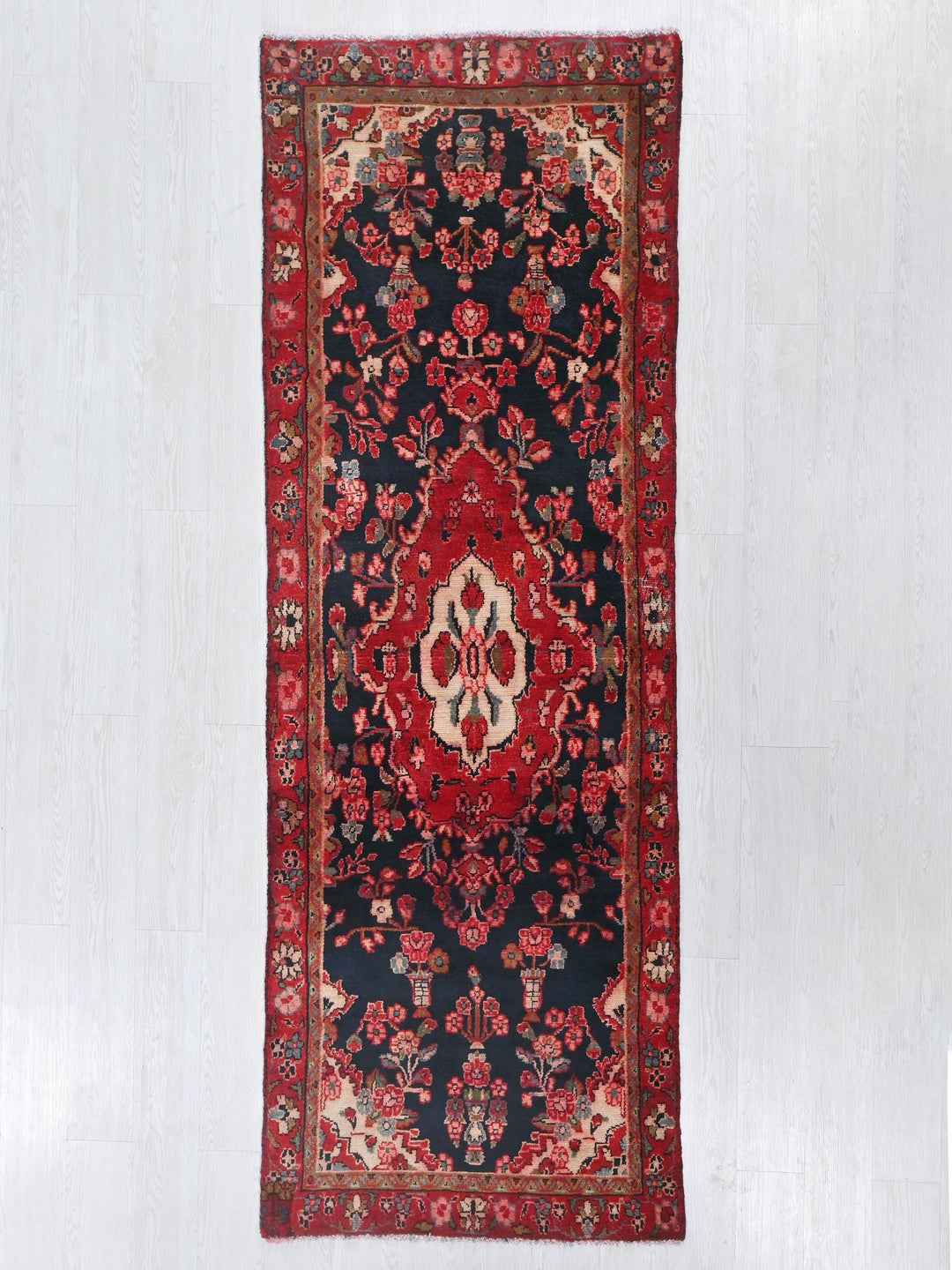a red and black rug hanging on a wall