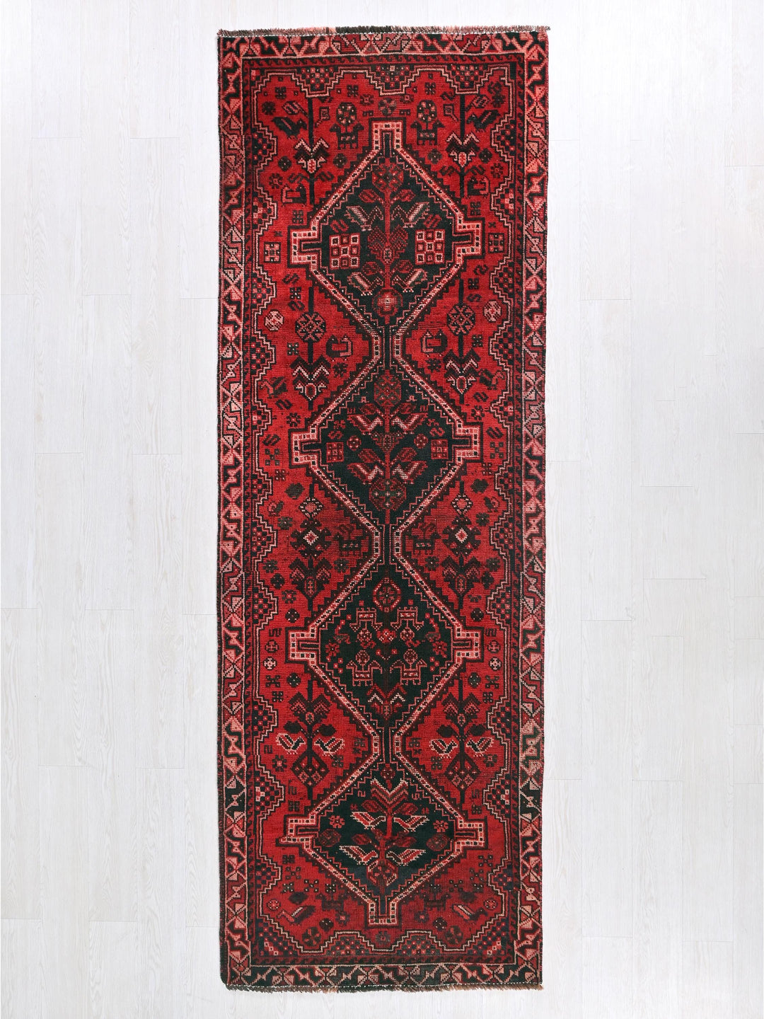 a red and black rug hanging on a wall