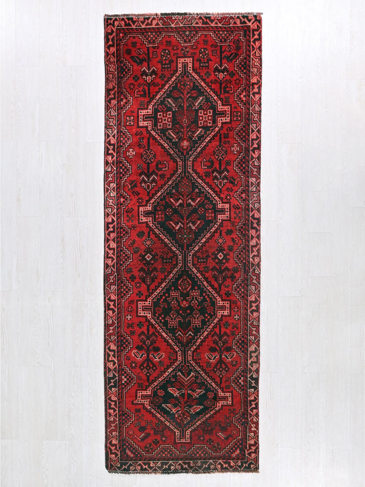 a red and black rug hanging on a wall
