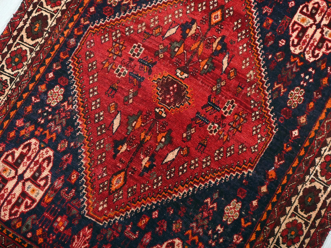 a red and blue oriental rug on a white floor
