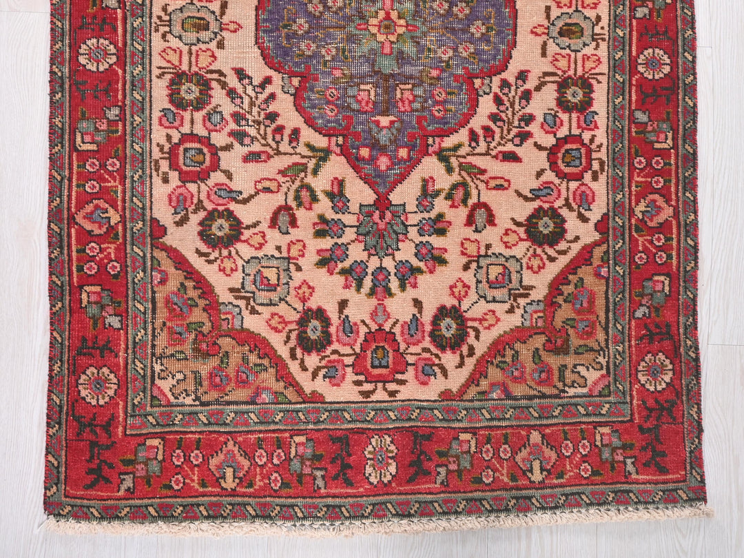 a red rug with a floral design on it
