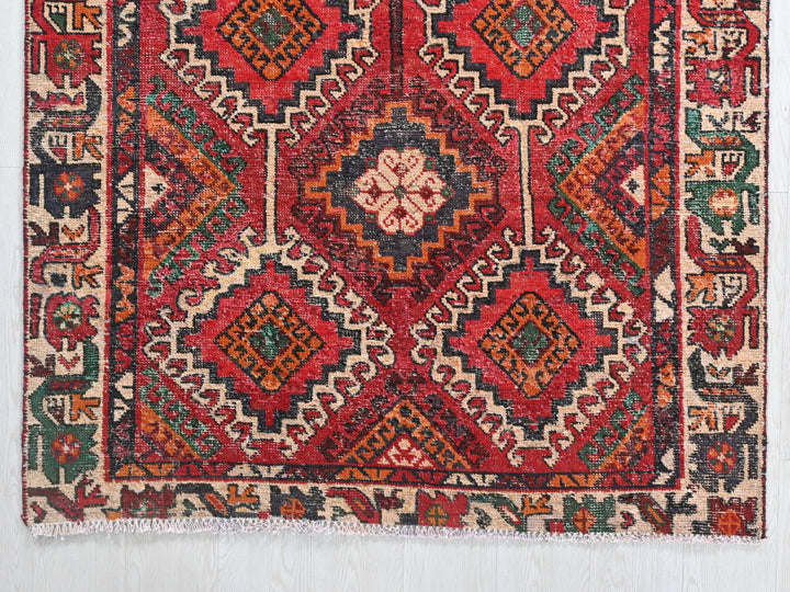a red rug with a diamond pattern on it