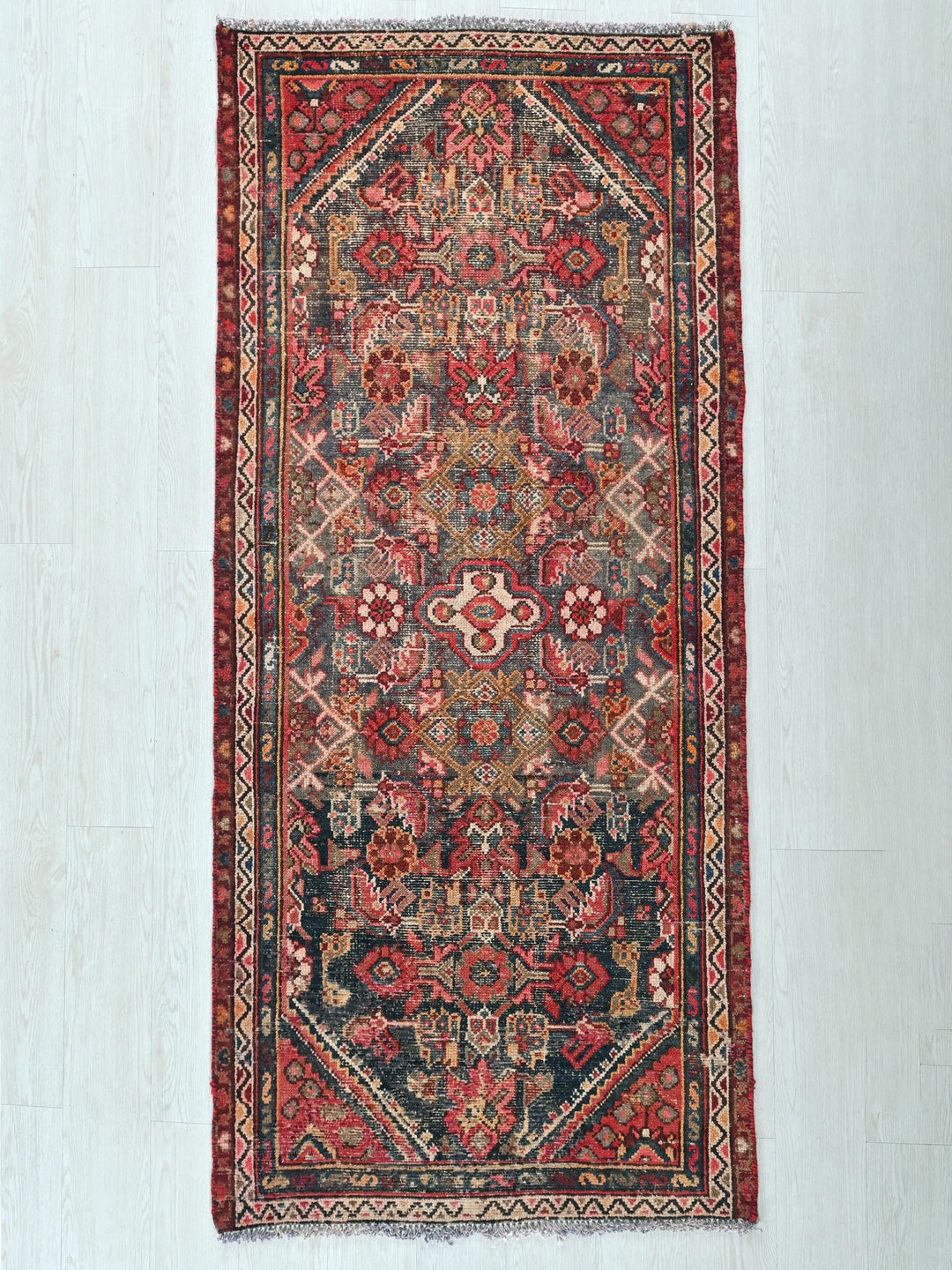 a red and blue oriental rug hanging on a wall