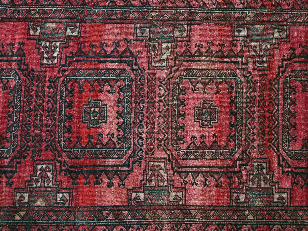 a red and black rug with a design on it