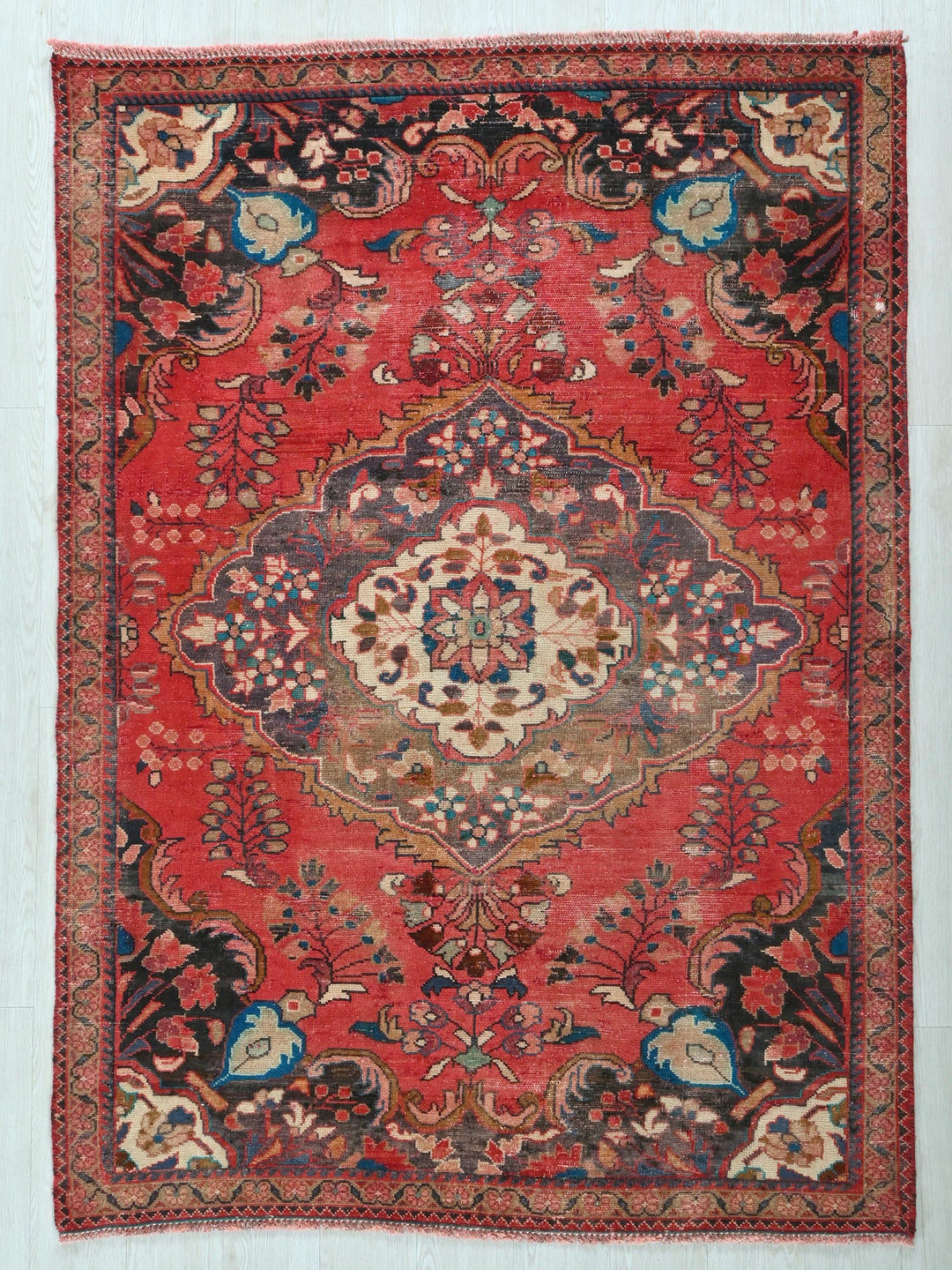 a red rug with a floral design on it