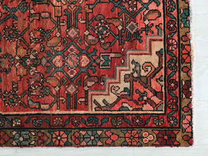 a red rug with a floral design on it