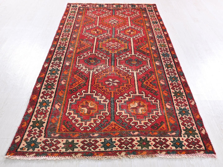 a red oriental rug on a white floor