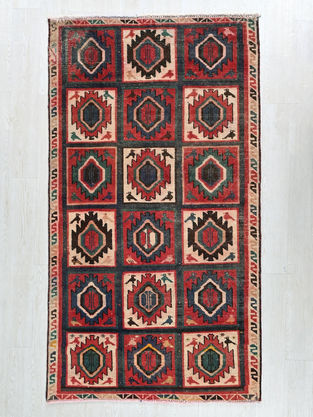a red and black rug on a white floor