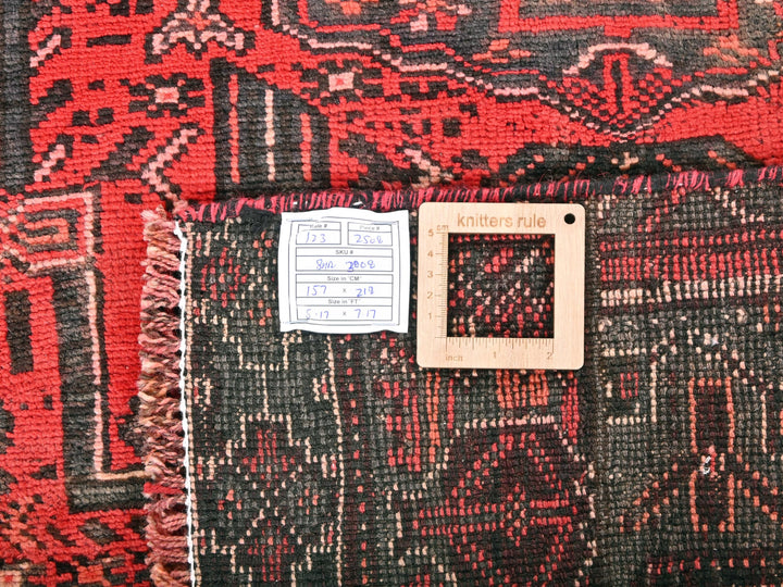 a close up of a red and black rug with a light switch
