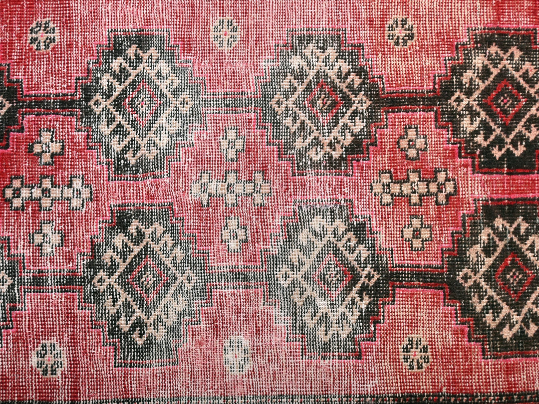 a red rug with black and white designs on it