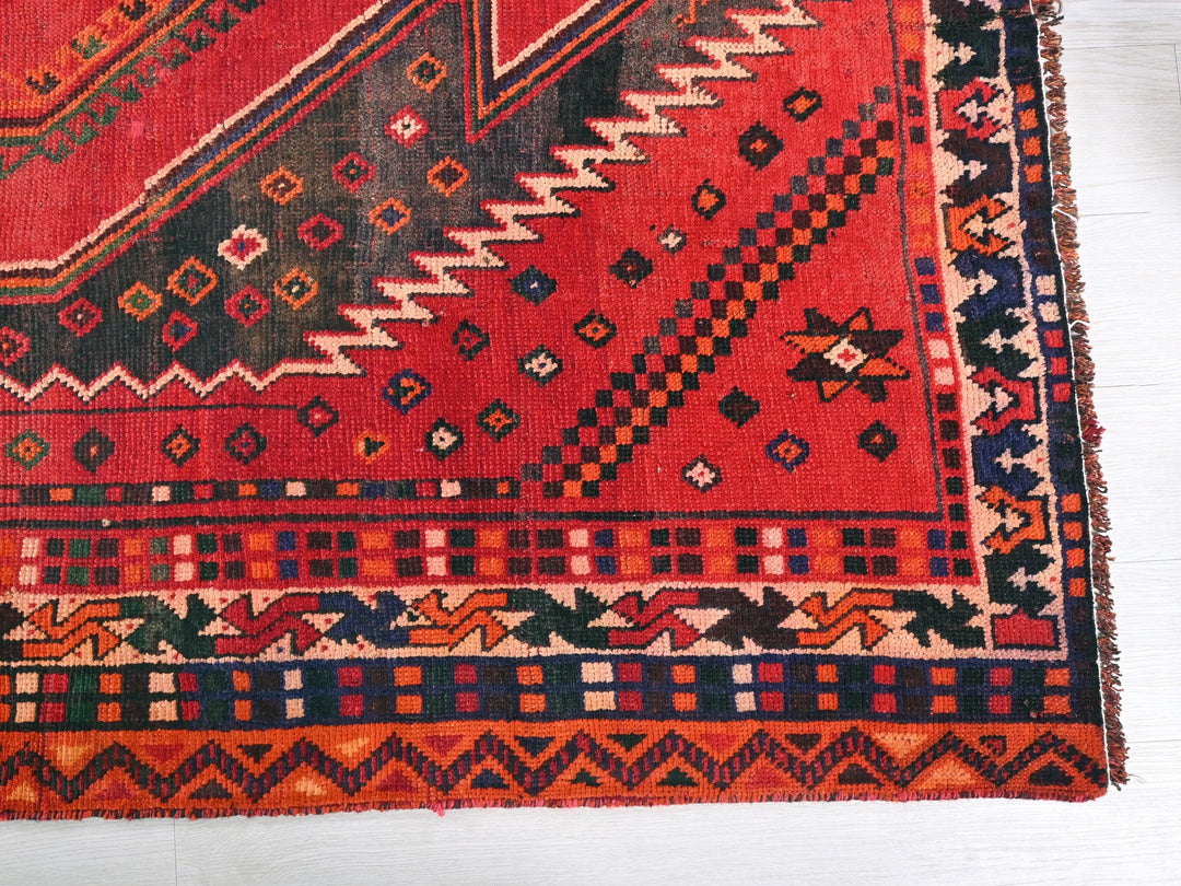 a red rug with a design on it