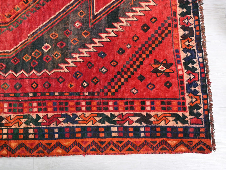 a red rug with a design on it