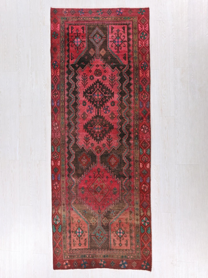 a red rug hanging on a wall