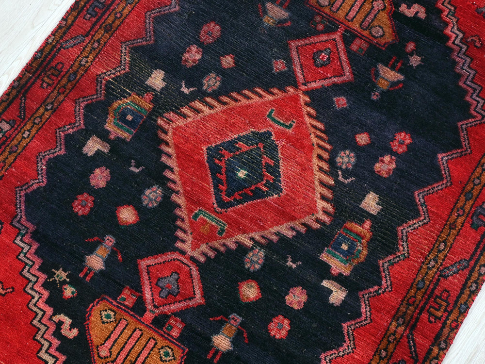 a red and black oriental rug with a diamond design