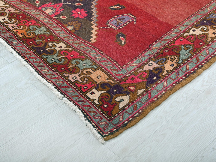 a red oriental rug on a white wooden floor