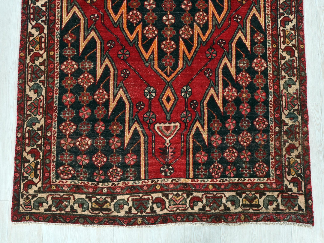 a red and black rug on a white floor