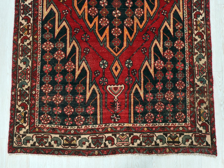 a red and black rug on a white floor