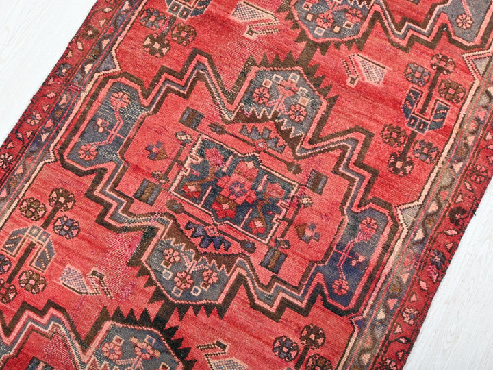a red rug on a white wooden floor