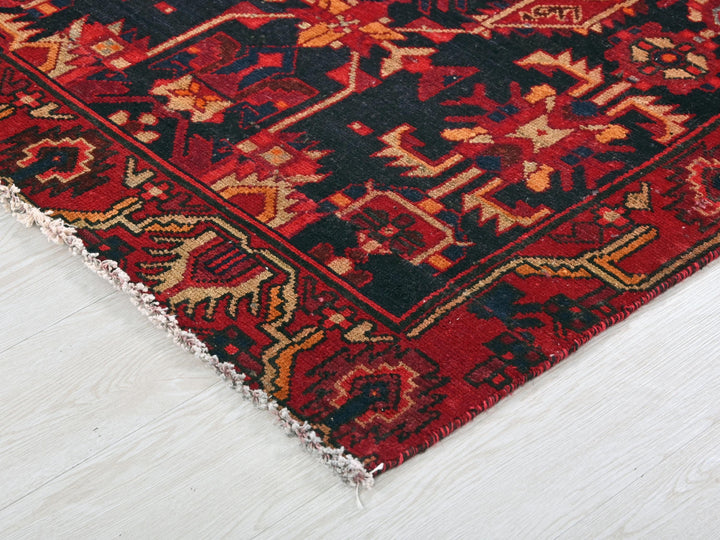a red and black oriental rug on a white floor