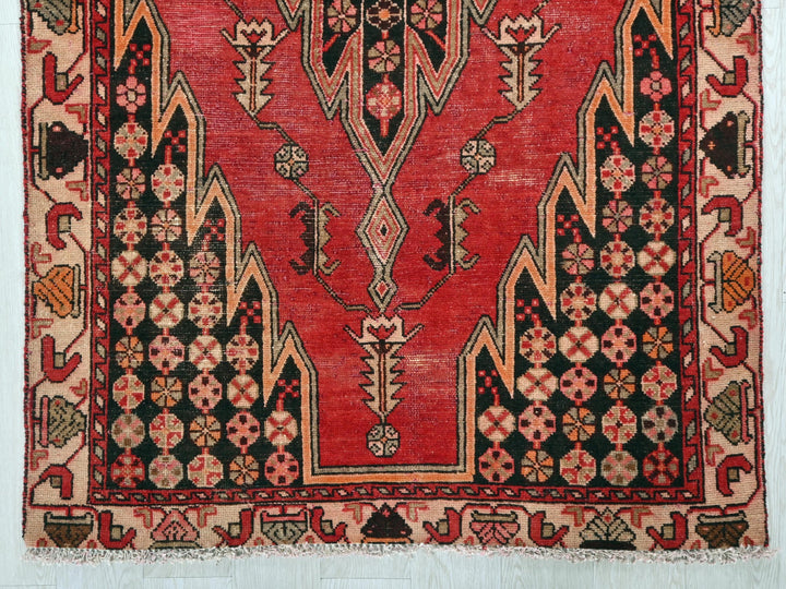 a red and black rug on a white wall