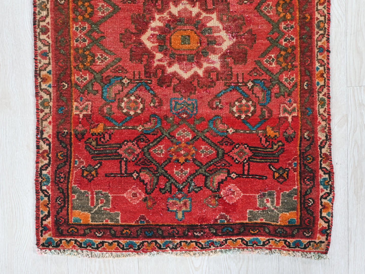 a red rug on a white wooden floor