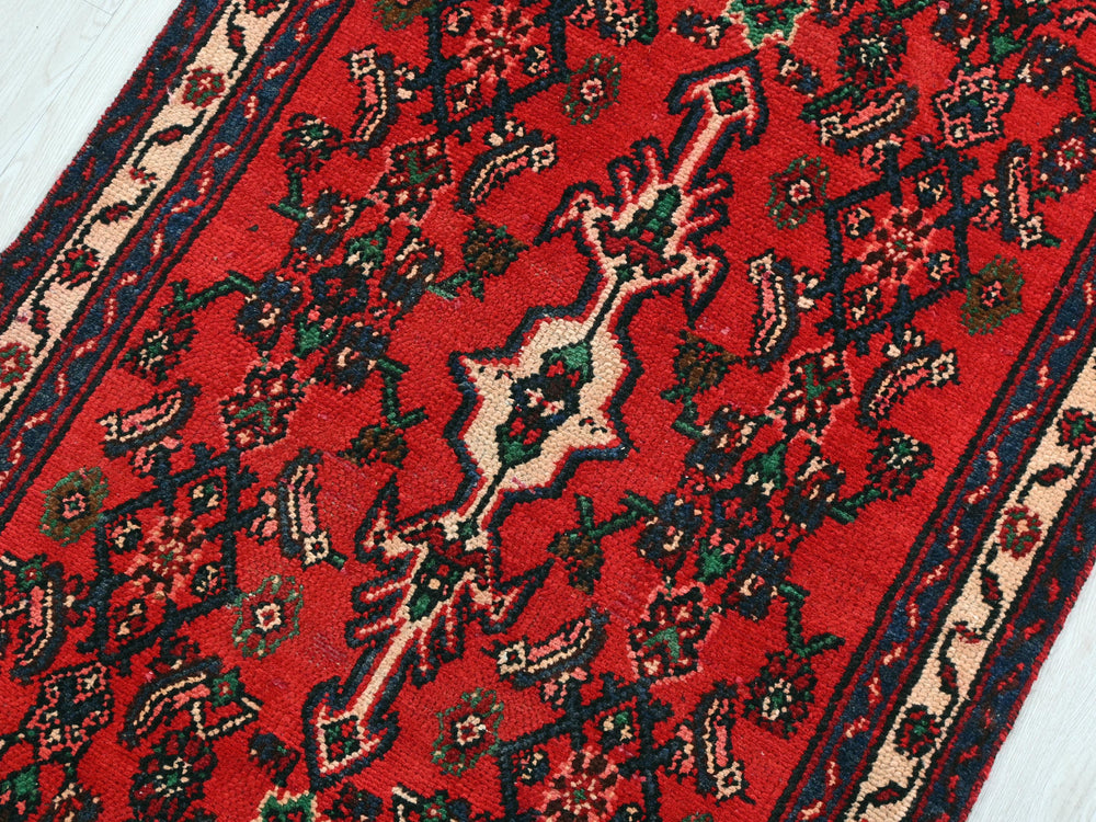 a red rug on a white wooden floor