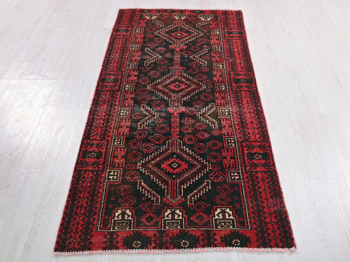 a red and black rug on a white floor