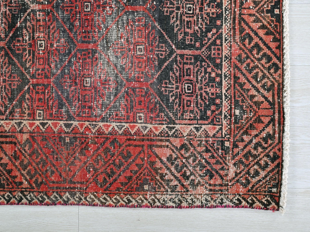 a red and black rug on a white floor