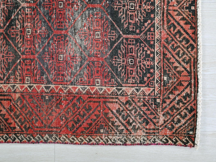 a red and black rug on a white floor