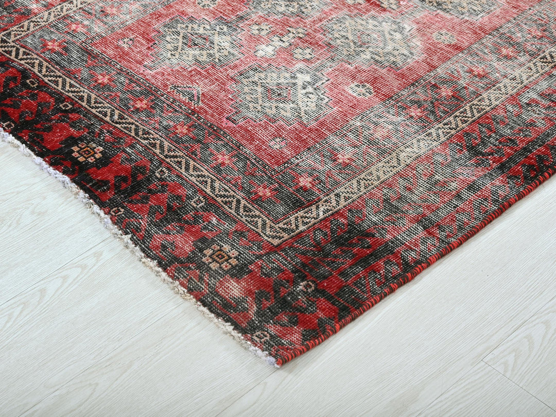 a red and black rug on a white floor