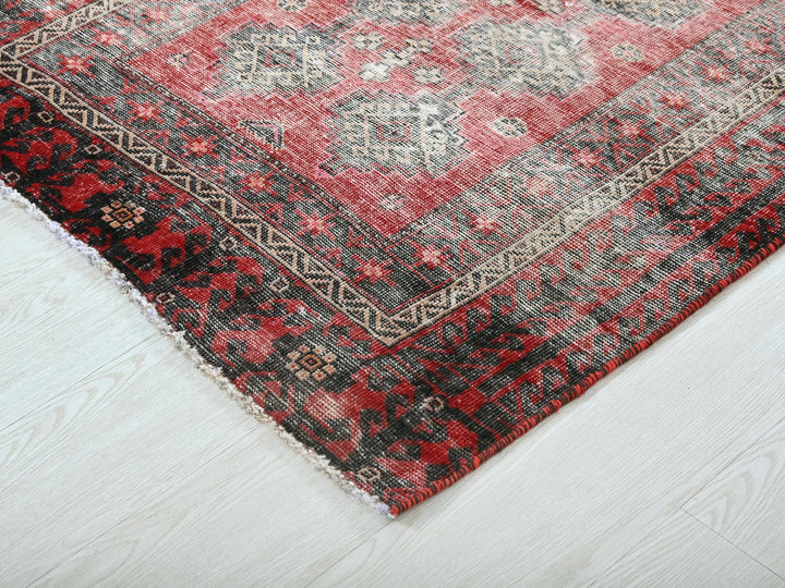 a red and black rug on a white floor
