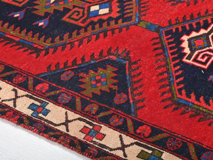 a close up of a red rug on a white surface