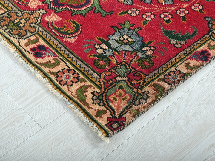 a red oriental rug on a white wooden floor