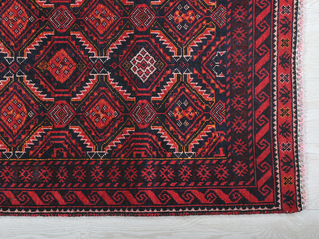 a red and black rug on a white surface