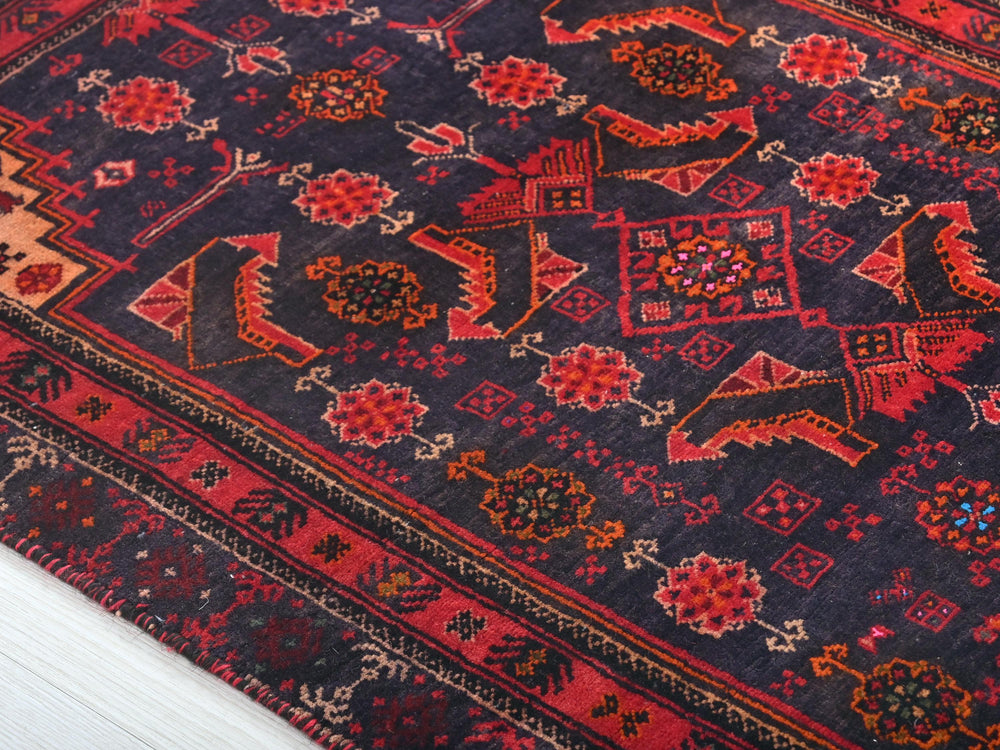 a red and blue rug on a white floor