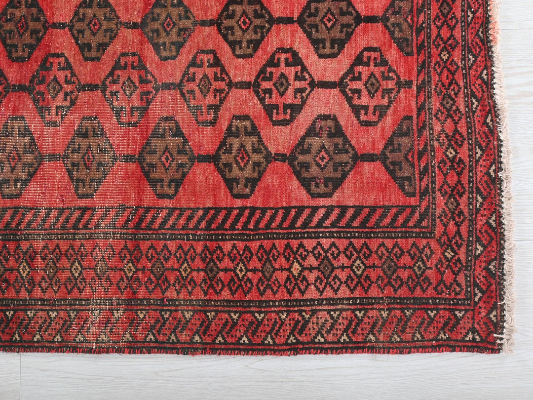 a red and black rug on a white surface