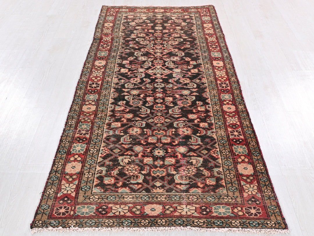 a red and black rug on a white floor