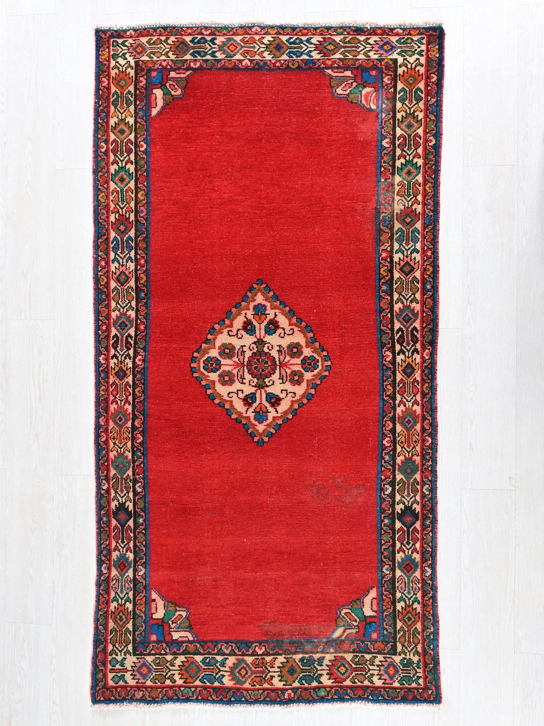 a red rug with a floral design on it