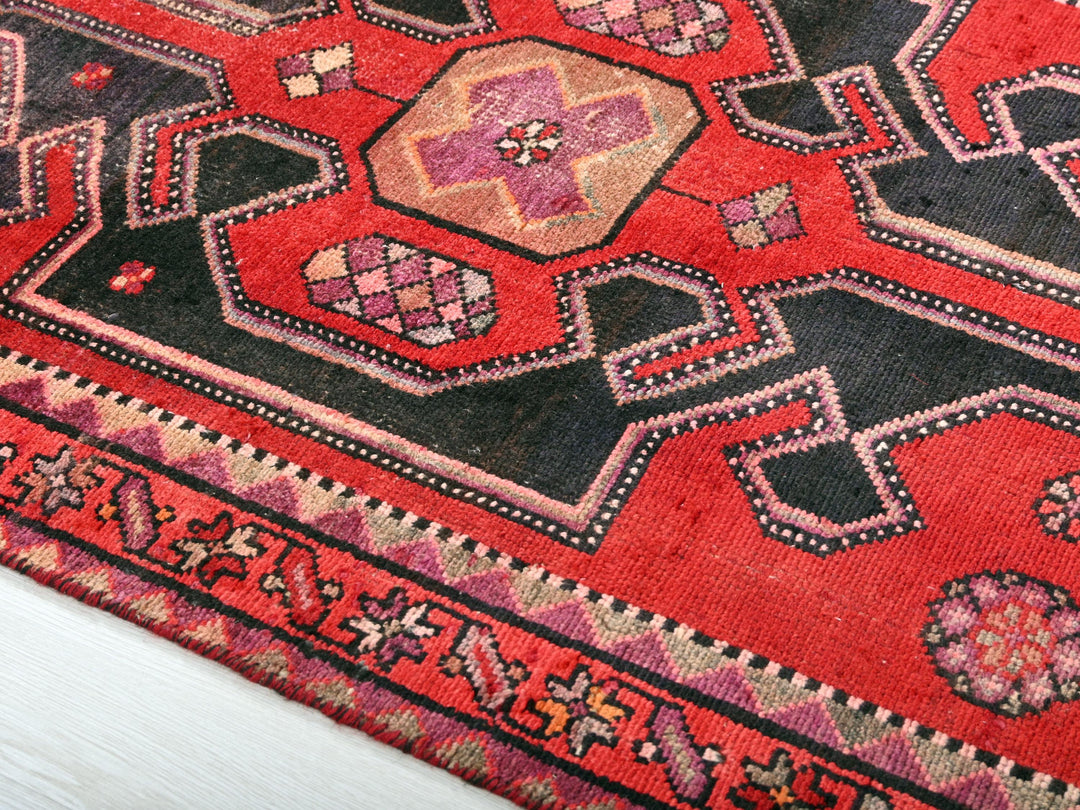 a close up of a red rug with a black border