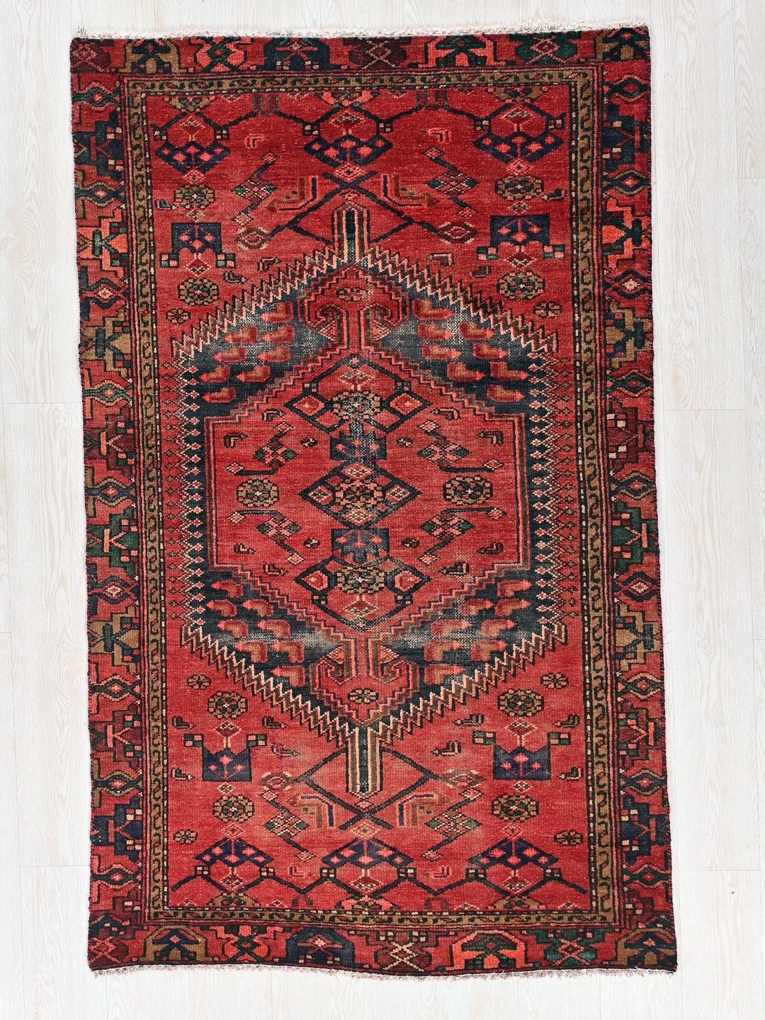 a red and black rug with a design on it