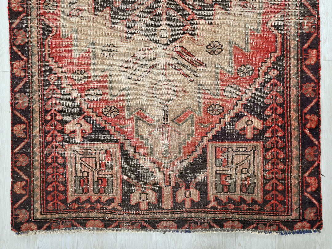 a red and black oriental rug on a white wall